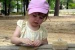 Young girl sitting at a picnic table.