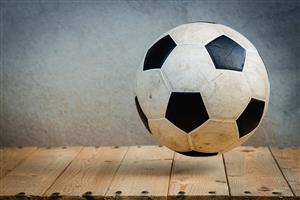 A Bouncing Soccer Ball Against A Hard Wood Floor