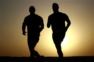 Silhouettes of men running in the sunset